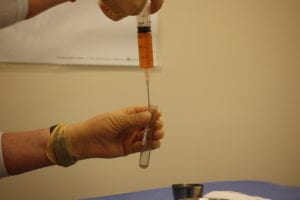 PRP being pulled into a syringe for injection