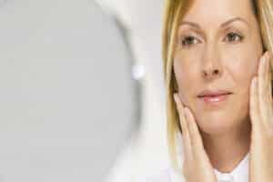 Woman adimring youthful skin after laser treatment in Austin, TX