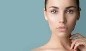 Woman showing smooth eyelids and lifted brows after facial rejuvenation.